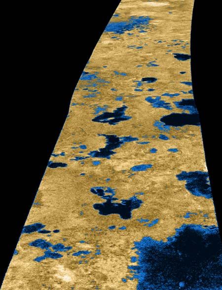 Figura 2.- Imagen en falsos colores de la superficie de Titán captada por la sonda Cassini de la NASA el 22 de julio de 2006. En color azul oscuro se aprecian varios de los lagos presentes en esta luna de Saturno. Crédito: NASA/JPL/USGS