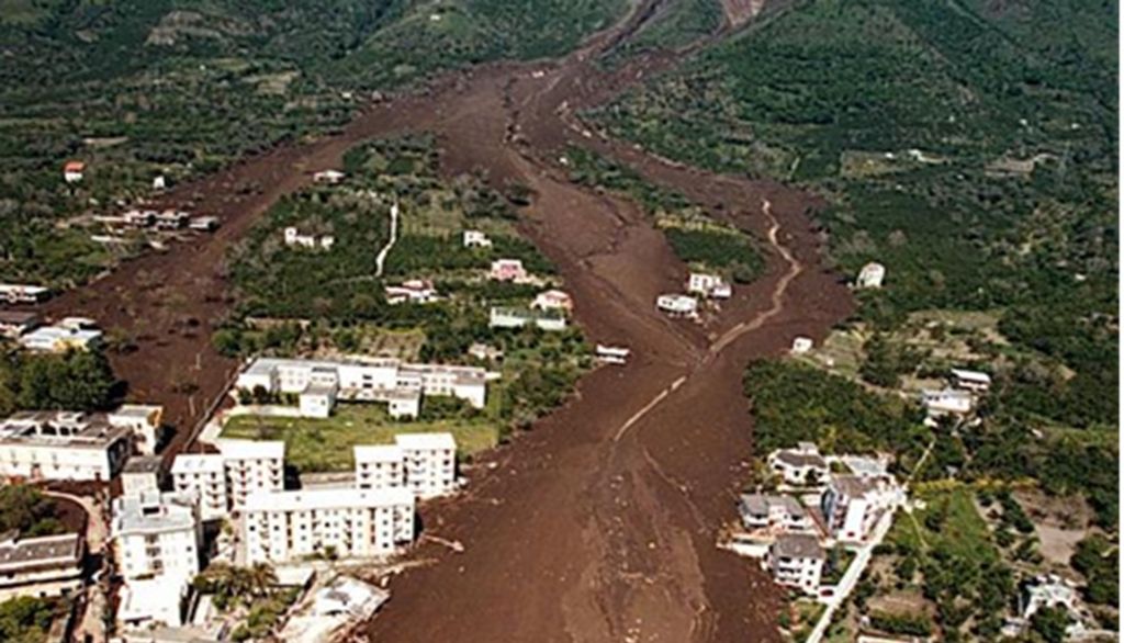 Frana di Sarno e Quindici 5-6 maggio 1998. Il paese di Sarno tagliato in due da uno dei fronti della frana. Fonte: Wikimedia Italia.