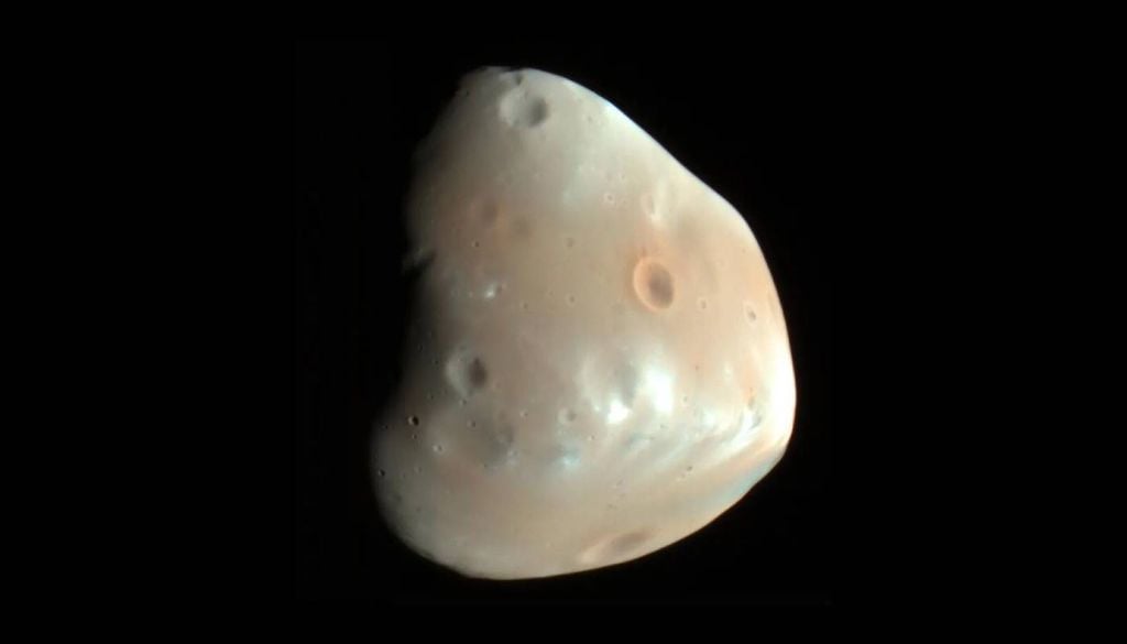 O impacto antigo de um asteroide poderá ter remodelado quase toda a superfície de Deimos, a menor e mais distantes das duas luas de Marte. Crédito: NASA/JPL-Caltech/Universidade do Arizona