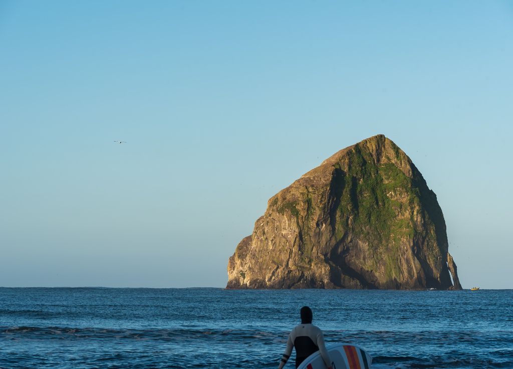Un surfeur aborde les vagues de Pacific City.