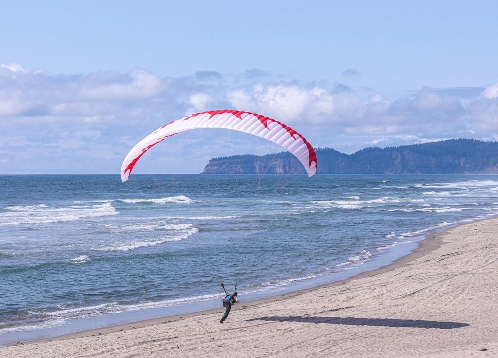 Un homme en parapente affronte le vent à Cape Kiwanda.