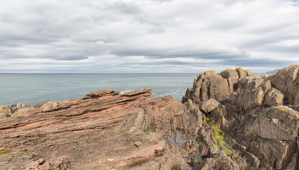 A famosa discordância angular de James Hutton em Siccar Point, em Berwickshire, Escócia. Arenito devoniano suavemente inclinado sobreposto a grauvaque siluriano quase vertical.