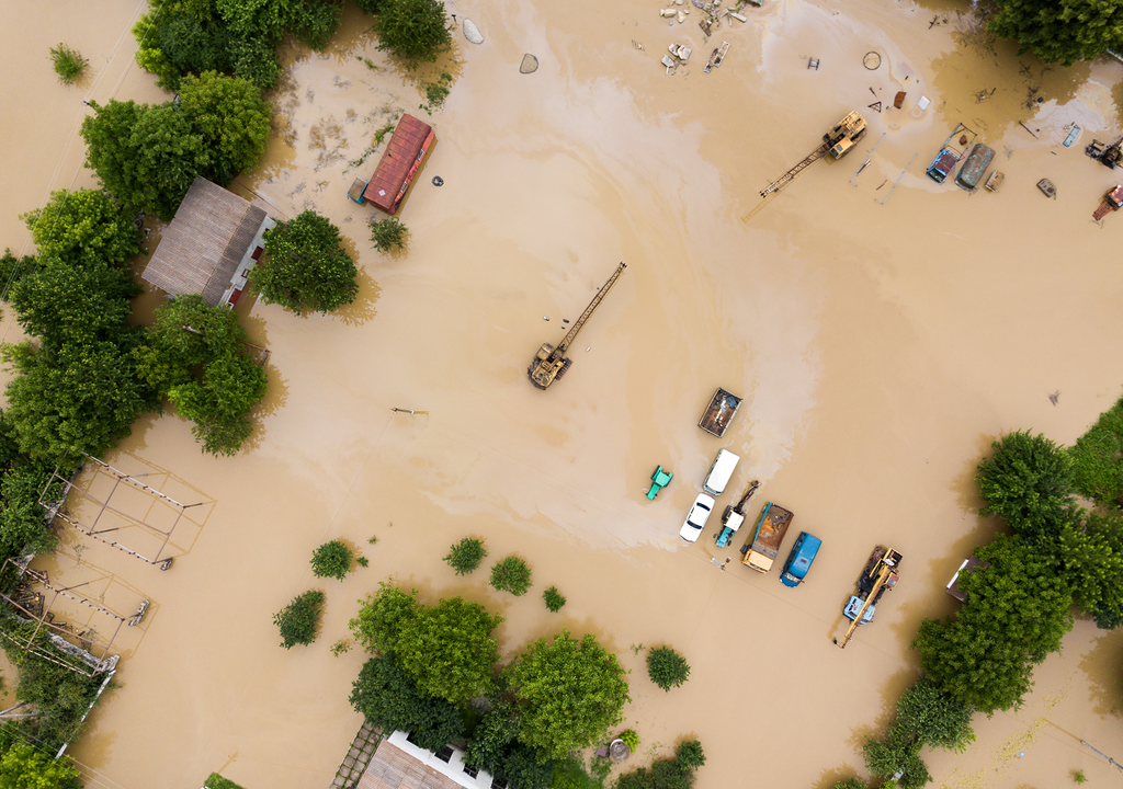 terreno inundado con vehículos y casas bajo el agua