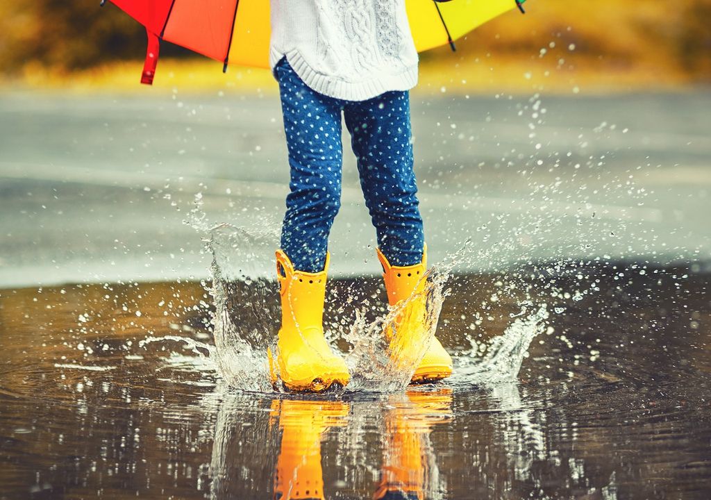 Niña chapoteando en una poza de agua