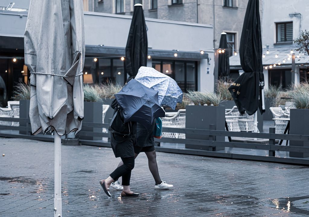 Lluvia; viento; personas protegiéndose