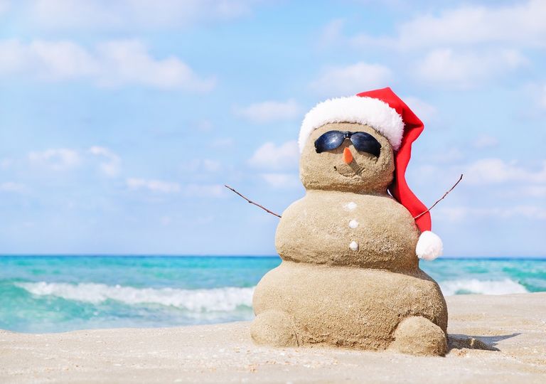 Muñeco de arena en la playa vestido con gorro de viejo pascuero Muñeco de arena en la playa vestido con gorro de viejo pascuero