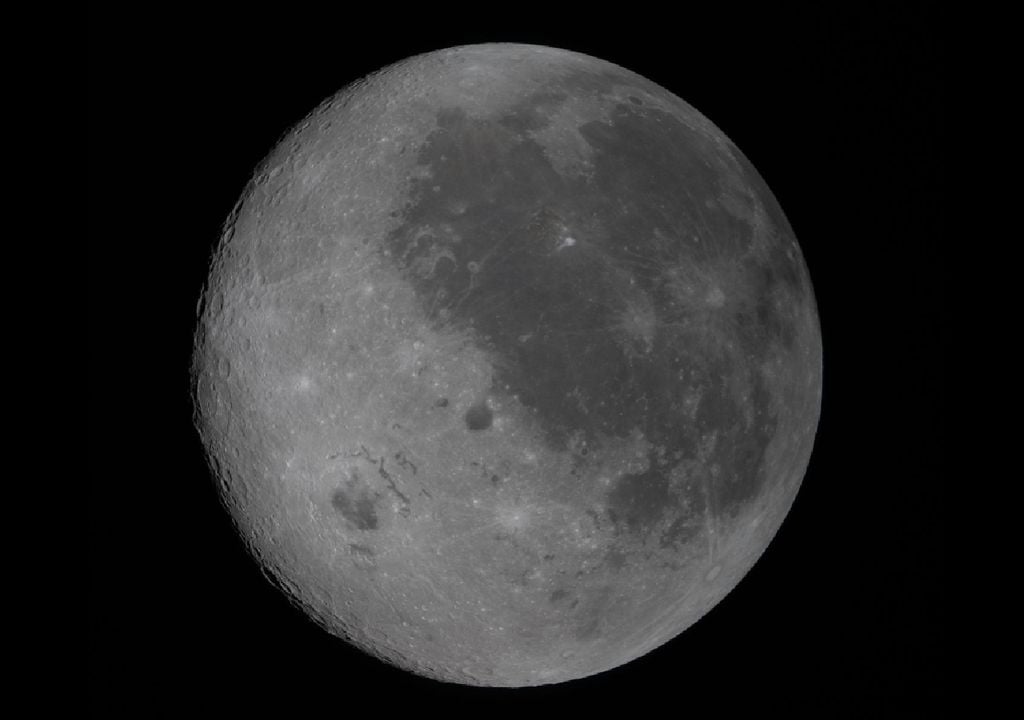 artemis II luna NASA Imagen del lado visible desde la Tierra, tomada desde Orion. Se identifica por las manchas oscuras que cubren su superficie. Se trata de antiguas coladas de lava de una época temprana en la historia de la Luna, cuando era volcánicamente activa. El gran cráter al oeste de las coladas de lava es la cuenca Orientale, un cráter de casi 965 kilómetros de ancho que se extiende a ambos lados de la Luna. Créditos: NASA.