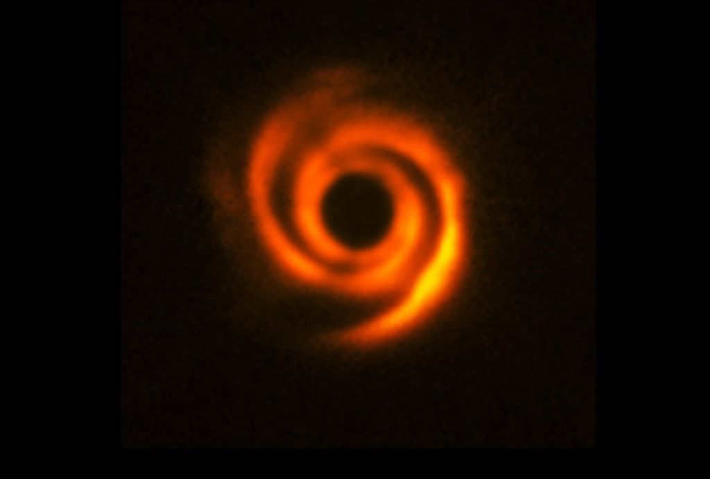 Imagem de 2016 mostra disco espiral de poeira ao redor da estrela HD 135344B, feita com o telescópio VLT. A estrela foi ocultada pelo círculo preto para destacar os detalhes. Sinais de um possível planeta só foram detectados em observações mais recentes. — Foto: ESO/T. Stolker et al