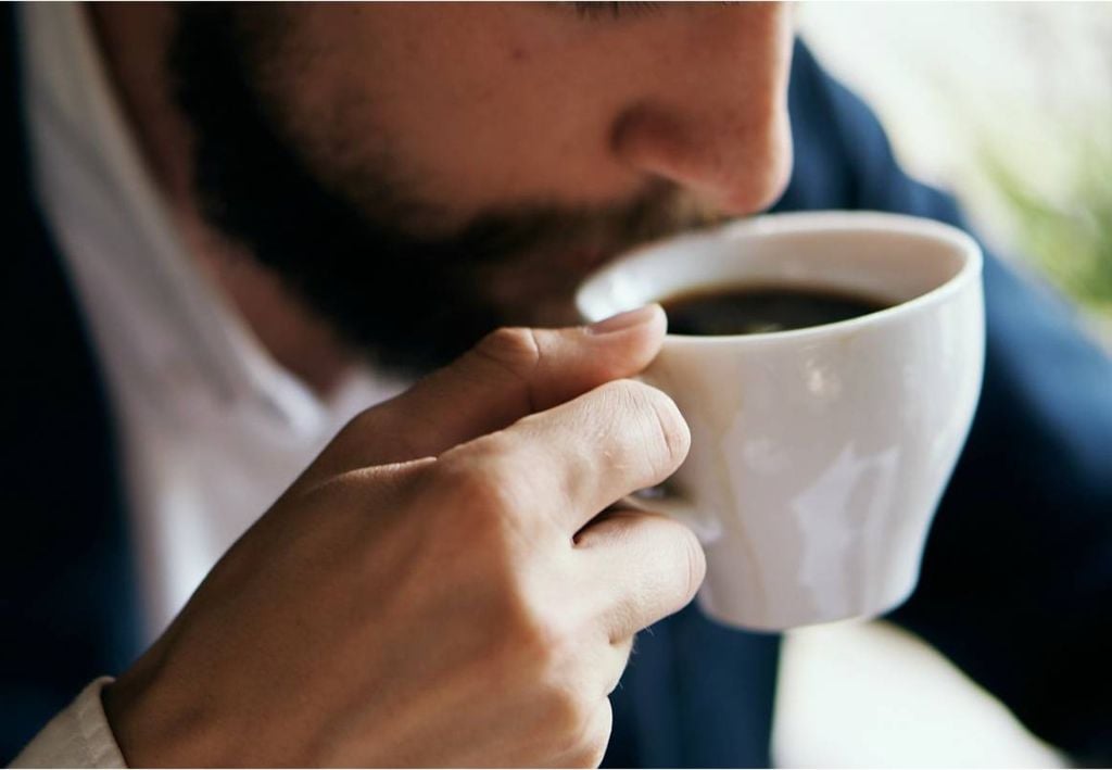 persona bebiendo café en una taza