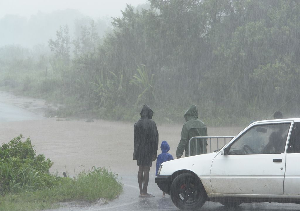 Familia intentando cruzar la carretera inundada