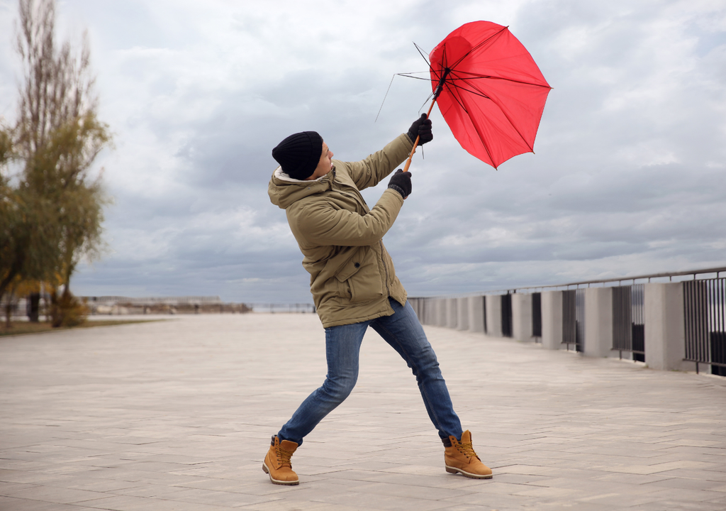 hombre con paragua roto por el viento