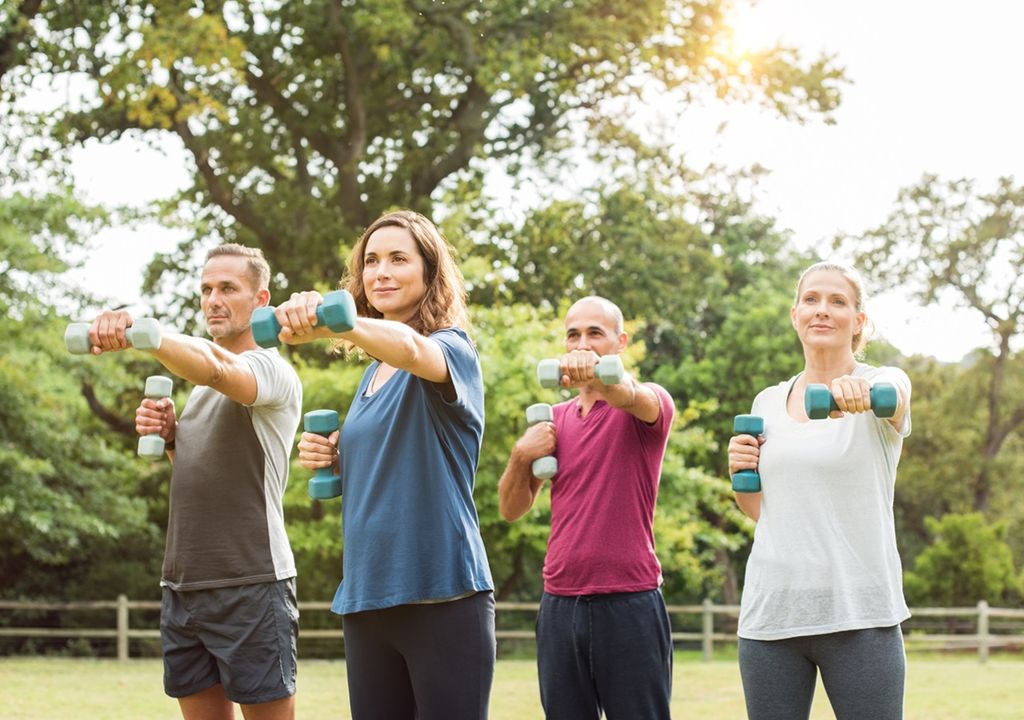 Pessoas treinando com pesos ao ar livre