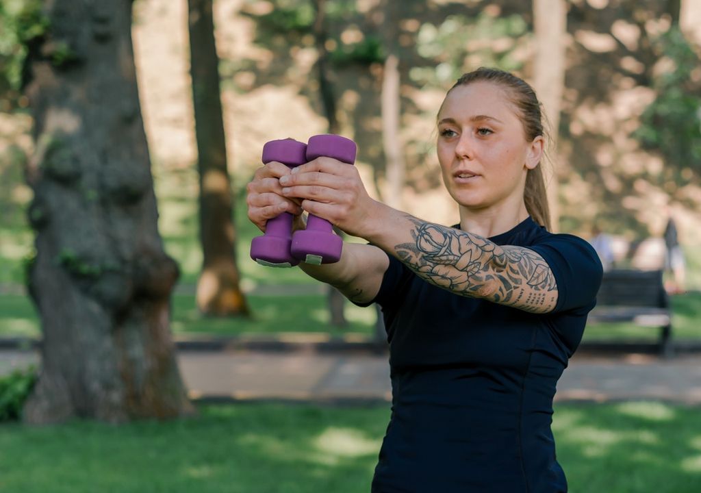Mulher treinando com pesos em um parque