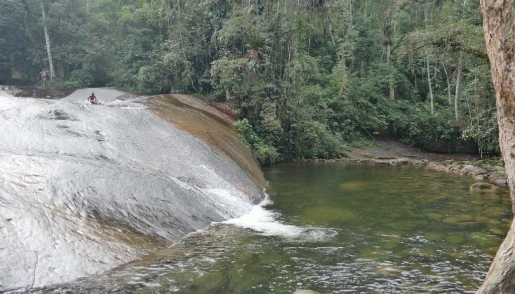A Cachoeira do Tobogã tem como principal atrativo a grande pedra lisa por onde corre o fluxo de água, formando um grande tobogã, onde se pode escorregar até cair em uma piscina natural. Crédito: Divulgação.