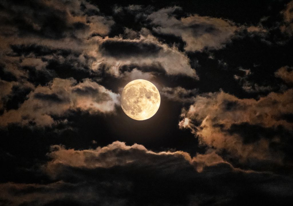 luna llena en un cielo con nubes