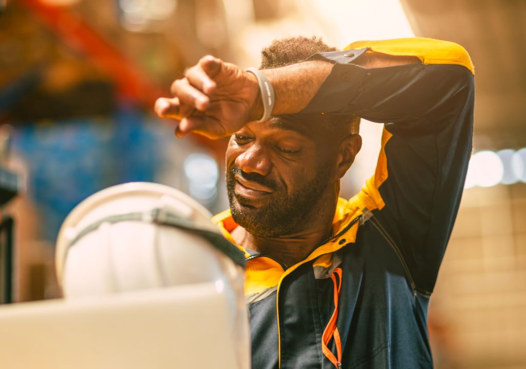 Trabalhador em obra civil sofrendo com calor intenso.