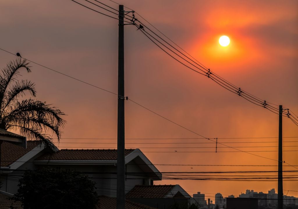Fotografia de céu sobre cidade durante episódio de onda de calor. Previsões indicam tendência de aumento das temperaturas na região Sul, que pode resultar em calor extremo especialmente sobre o estado gaúcho, junto à ausência de nebulosidade e chuva.