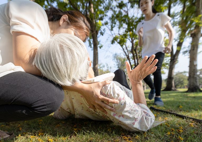 Adulto mayor caído en el suelo; personas la ayudan Adulto mayor caído en el suelo; personas la ayudan