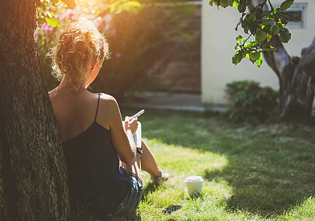 persona sentada bajo un árbol en un día de calor
