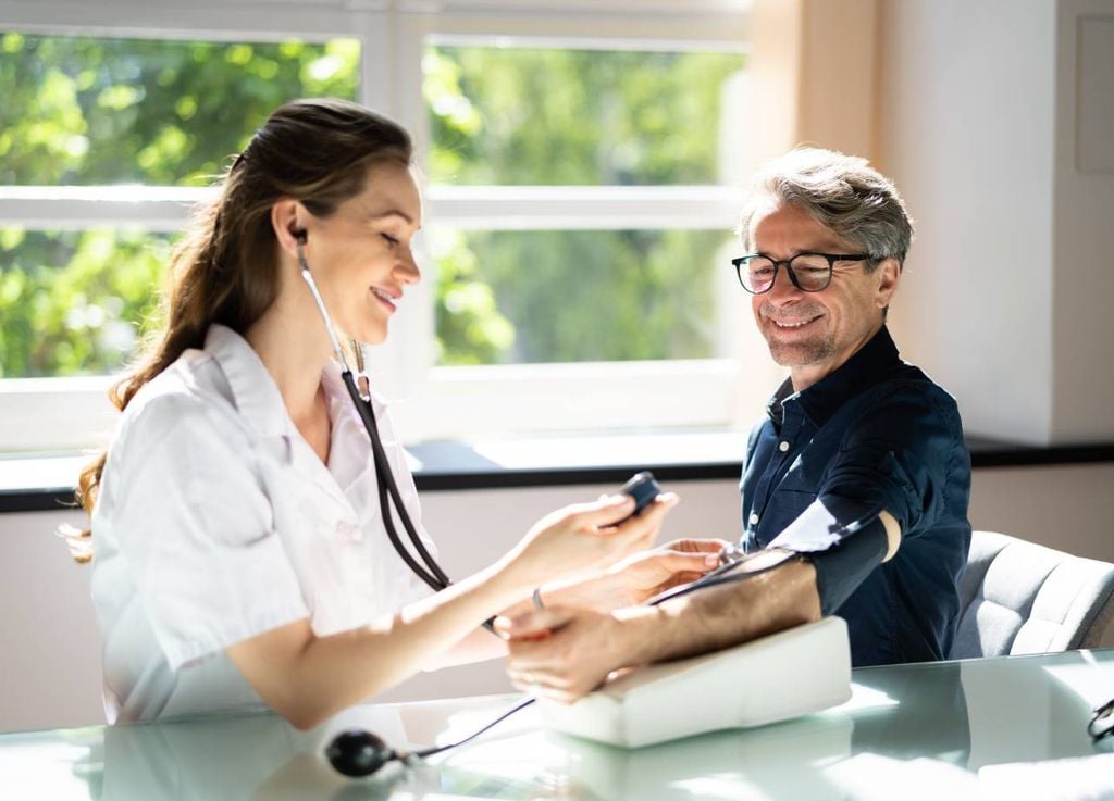 médica midiendo la presión arterial del paciente médica midiendo la presión arterial del paciente