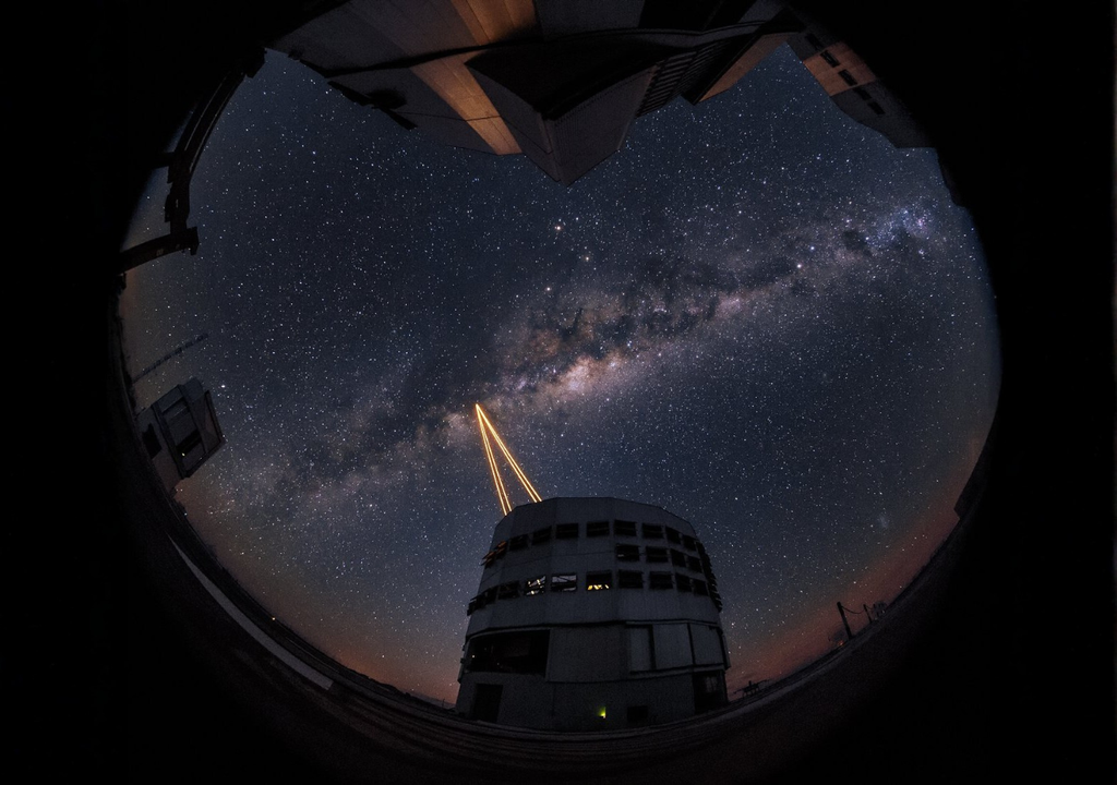 Láseres de óptica adaptativa del Very Large Telescope (VLT) en el Observatorio Paranal, Chile, crean estrellas guía artificiales mientras la Vía Láctea se extiende sobre el desierto de Atacama. Crédito: ESO / Y. Beletsky (LCO)