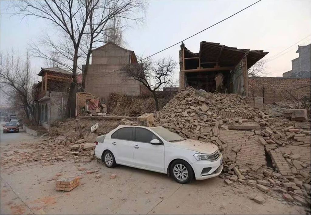 casas en el suelo y vehículo blanco cubierto con escombros