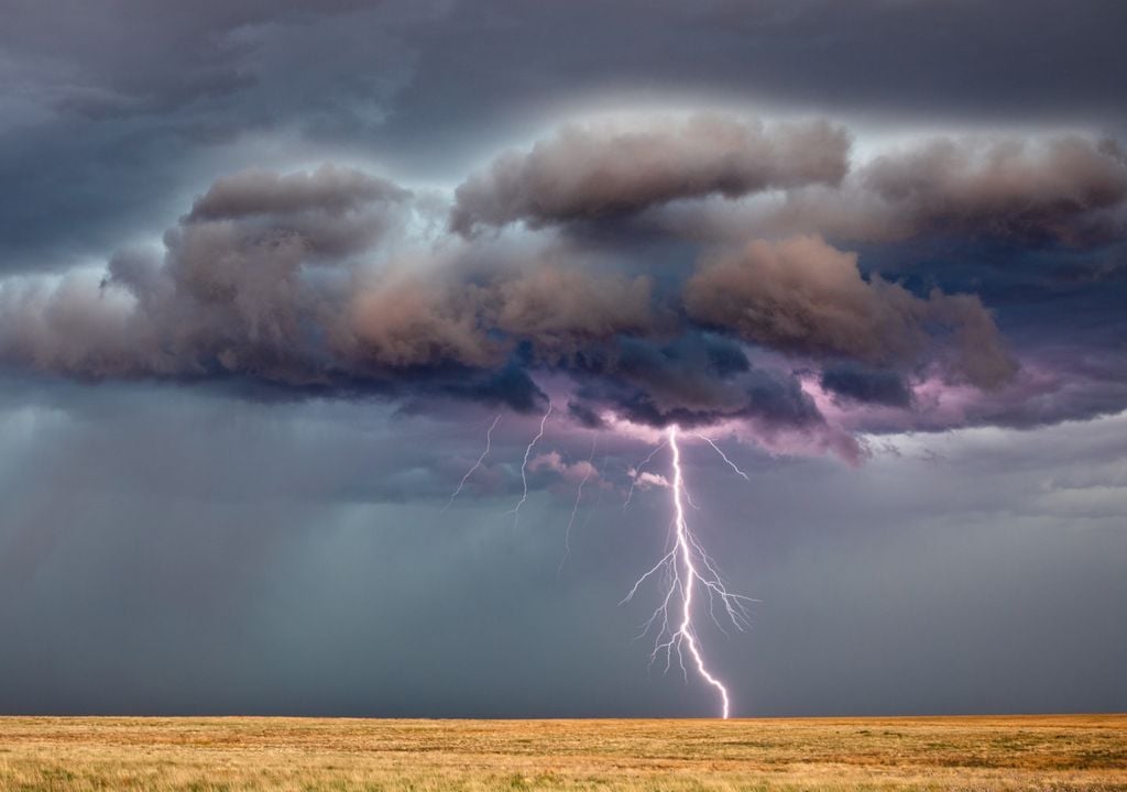Fotografia de tempestade com chuvas intensas e raios avançando.