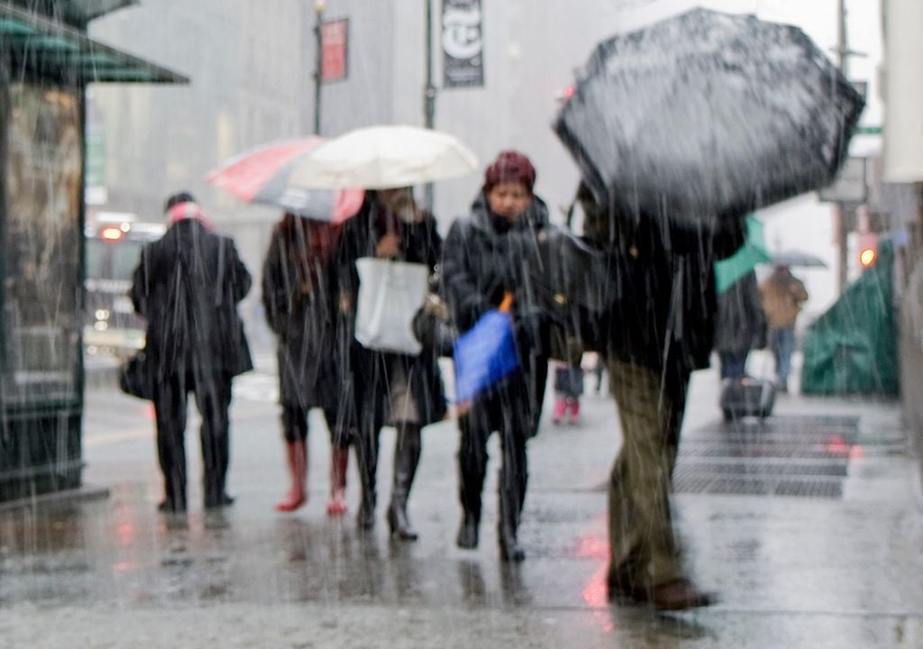 personas caminando bajo la lluvia