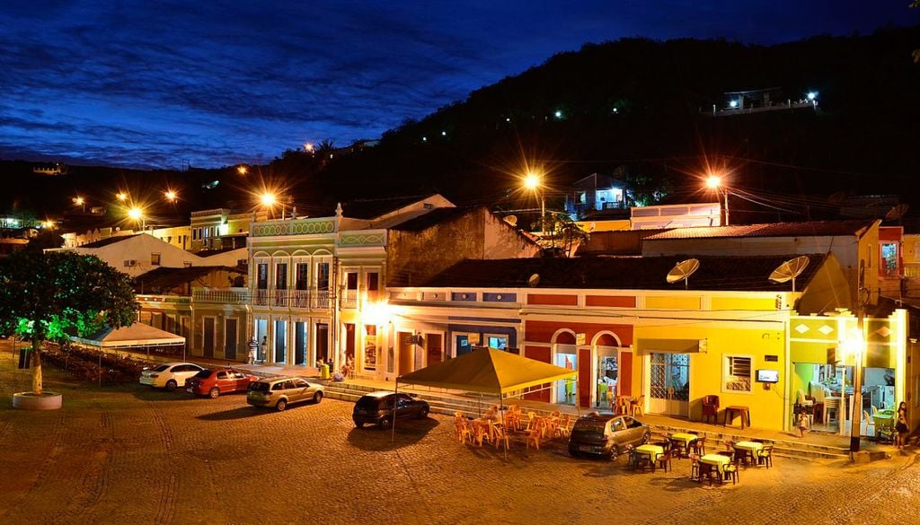 Centro Histórico de Piranhas (Alagoas) à noite, com algumas mesas na rua ao ar livre. Crédito: Divulgação.