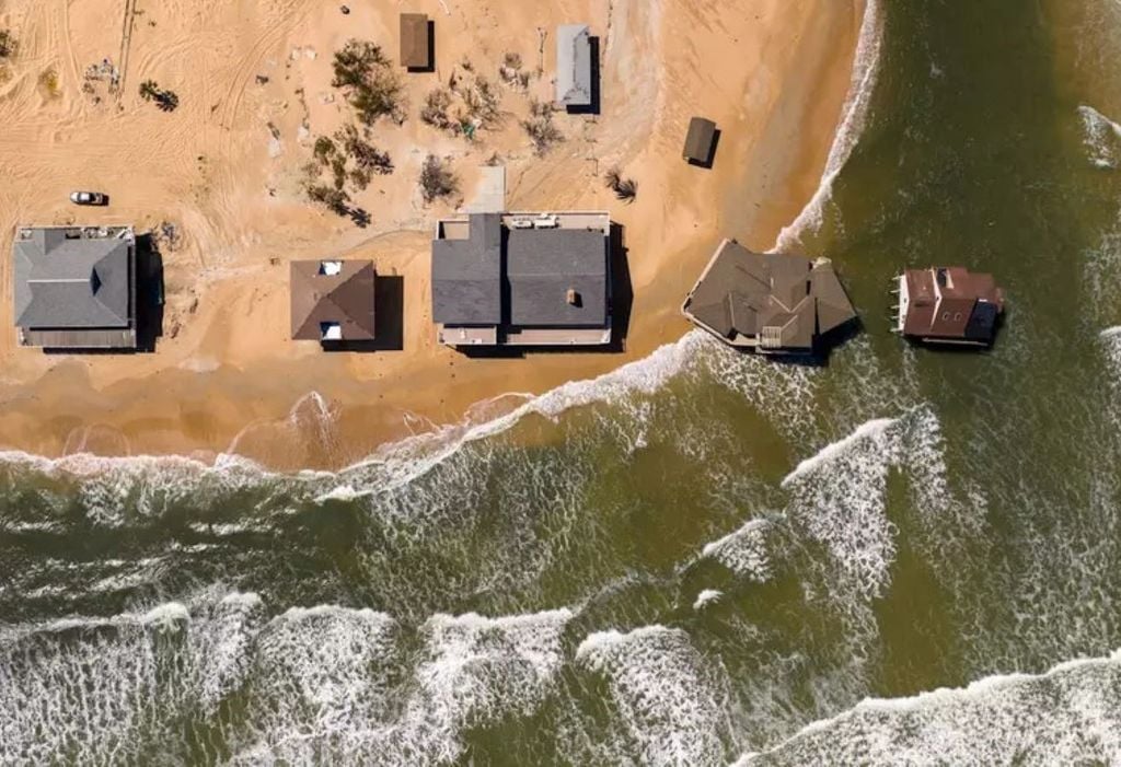 El aumento del nivel del mar altera las líneas costeras, poniendo en peligro viviendas y poblaciones: muchos lugares experimentan un aumento superior a la media mundial, mientras que otros cercanos a la capa de hielo pueden incluso ver cómo desciende el nivel del mar, y la razón principal tiene que ver con la gravedad. Aerial Views/E+/Getty Images El aumento del nivel del mar altera las líneas costeras, poniendo en peligro viviendas y poblaciones: muchos lugares experimentan un aumento superior a la media mundial, mientras que otros cercanos a la capa de hielo pueden incluso ver cómo desciende el nivel del mar, y la razón principal tiene que ver con la gravedad. Aerial Views/E+/Getty Images