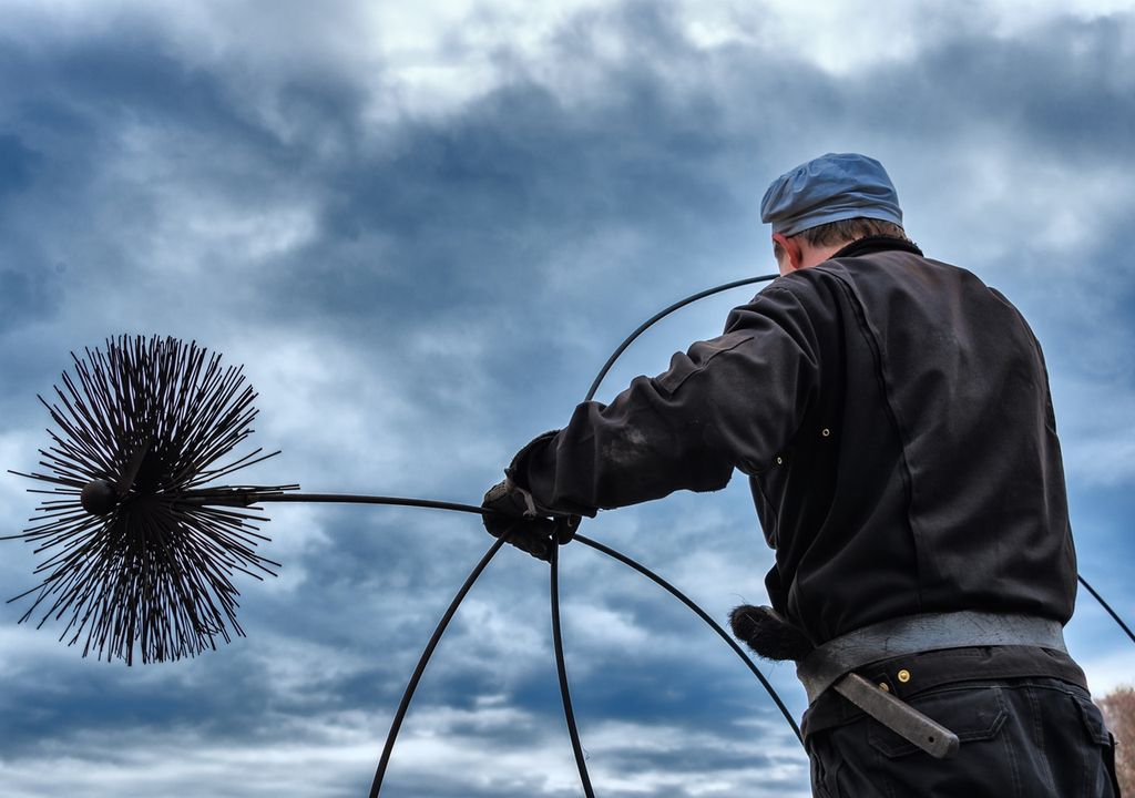 persona con una limpiador de chimenea en sus manos