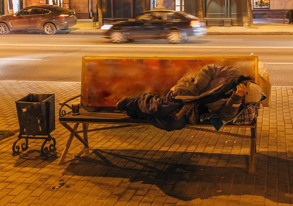 Persona durmiendo en un banco durante la noche