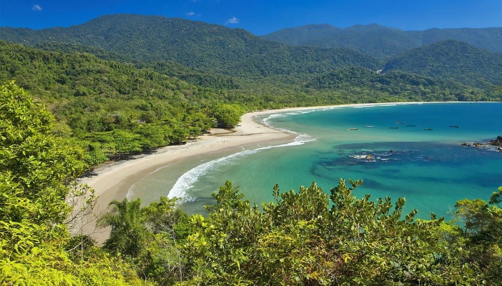 A famosa Praia de Castelhanos, com formato de coração vista de cima, no lado mais selvagem de Ilhabela (SP). É muito visitada por turistas e oferece restaurantes e belas paisagens. Crédito: Divulgação.