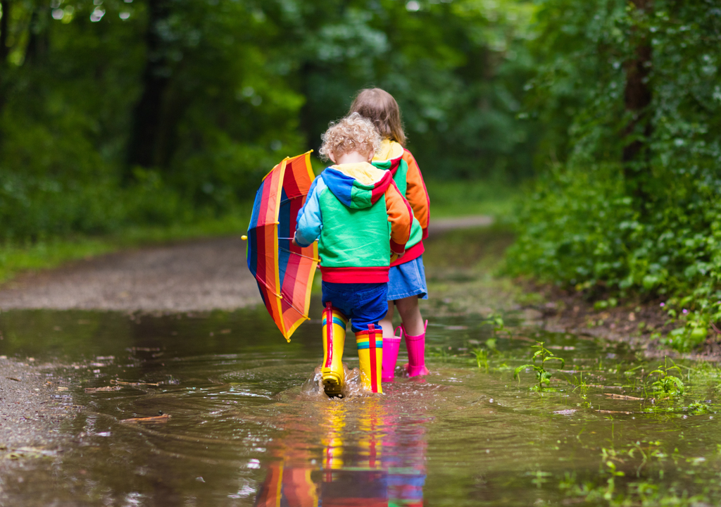 niños jugando con agua de lluvia