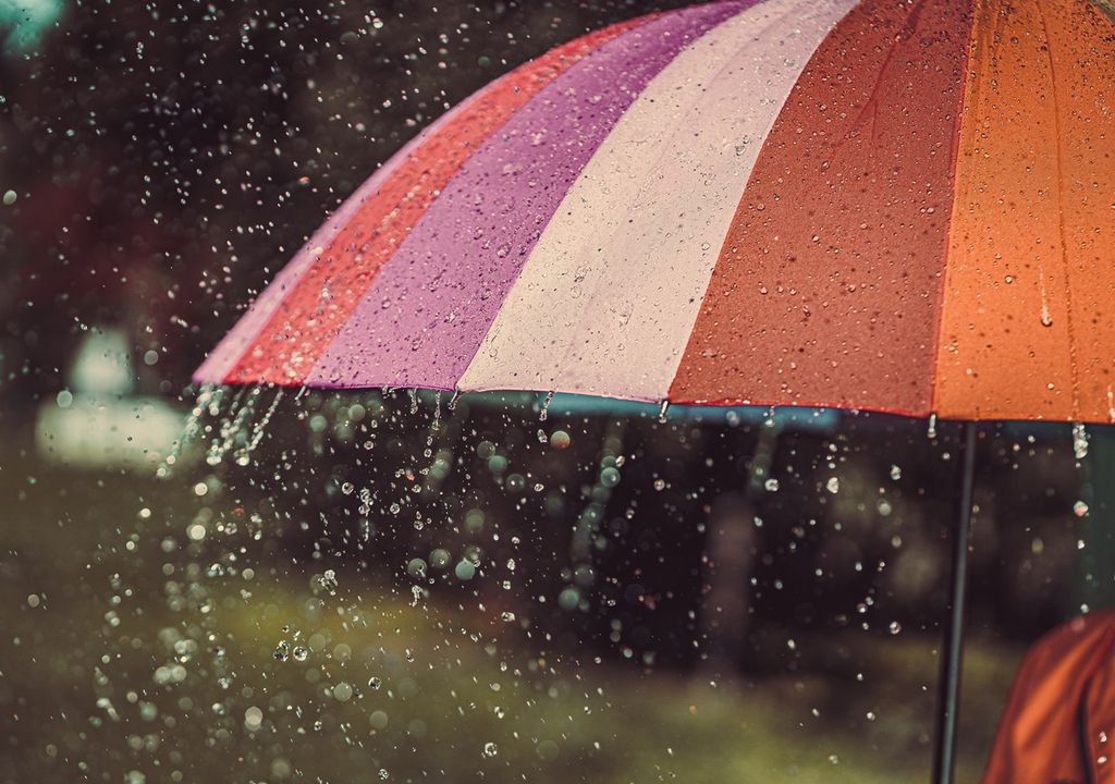 paragua de colores cálidos bajo la lluvia