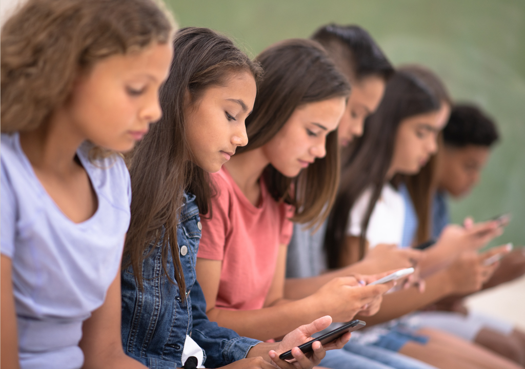 Adolescentes viendo pantallas.