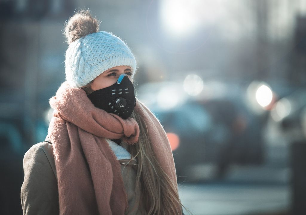 Mujer usando mascarilla en invierno Mujer usando mascarilla en invierno