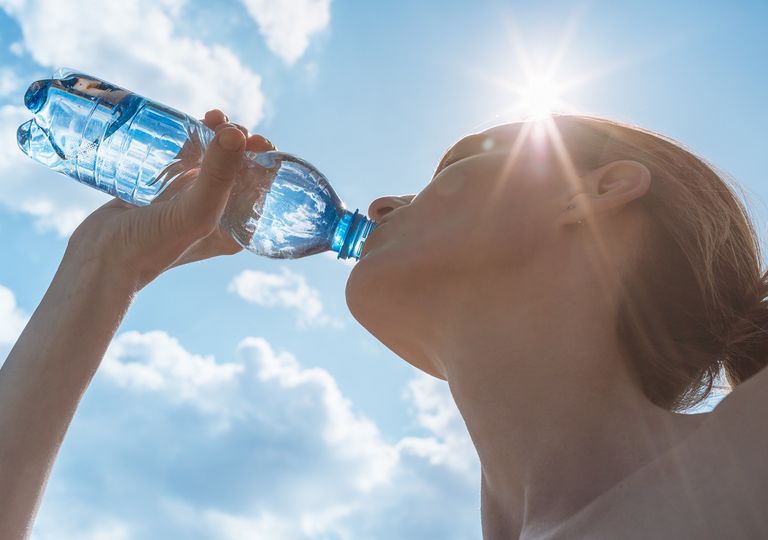 Mujer bebiendo agua en una botella Mujer bebiendo agua en una botella