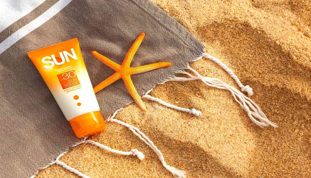 Crema solar sobre una toalla en la playa La crema solar se prohíbe en algunas playas de distintos países. Las restricciones responden al daño directo sobre corales y hábitats costeros.