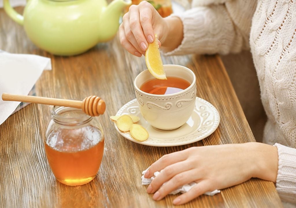 Mujer preparando té de jengibre con miel y limón