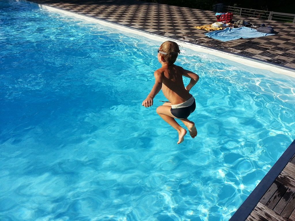 Niño saltando en la piscina