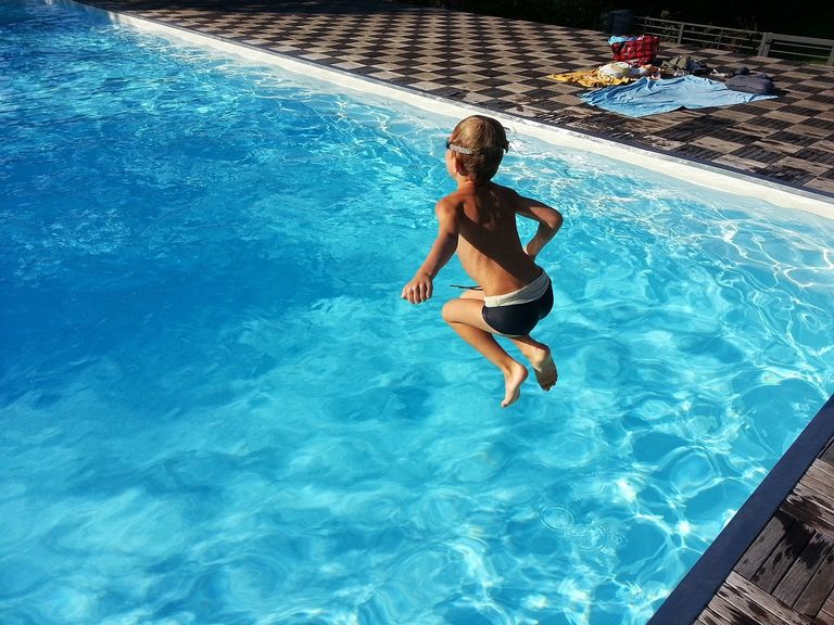 Niño saltando en la piscina Niño saltando en la piscina