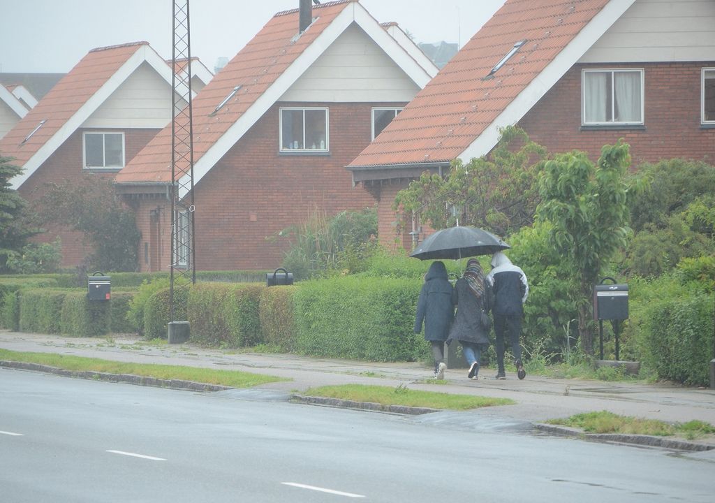 personas caminando bajo la lluvia; calles; casas