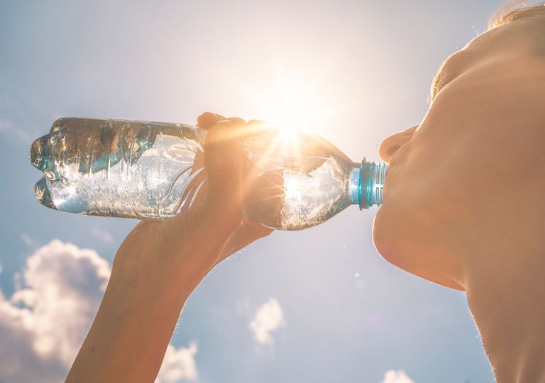 Mujer bebe agua en verano Mujer bebe agua en verano