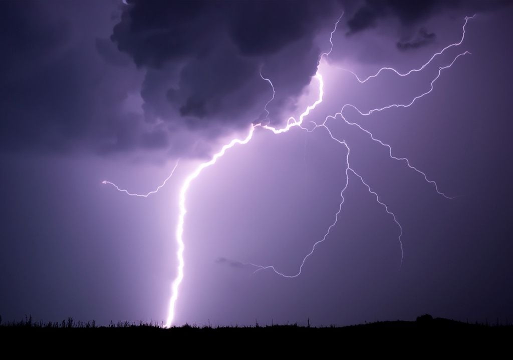 Rayos saliendo desde una nube en una noche de tormenta