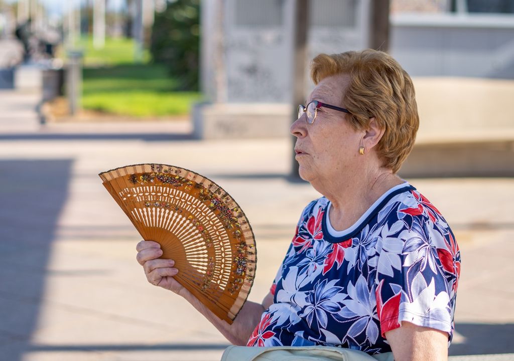 persona adulto mayor abanicándose