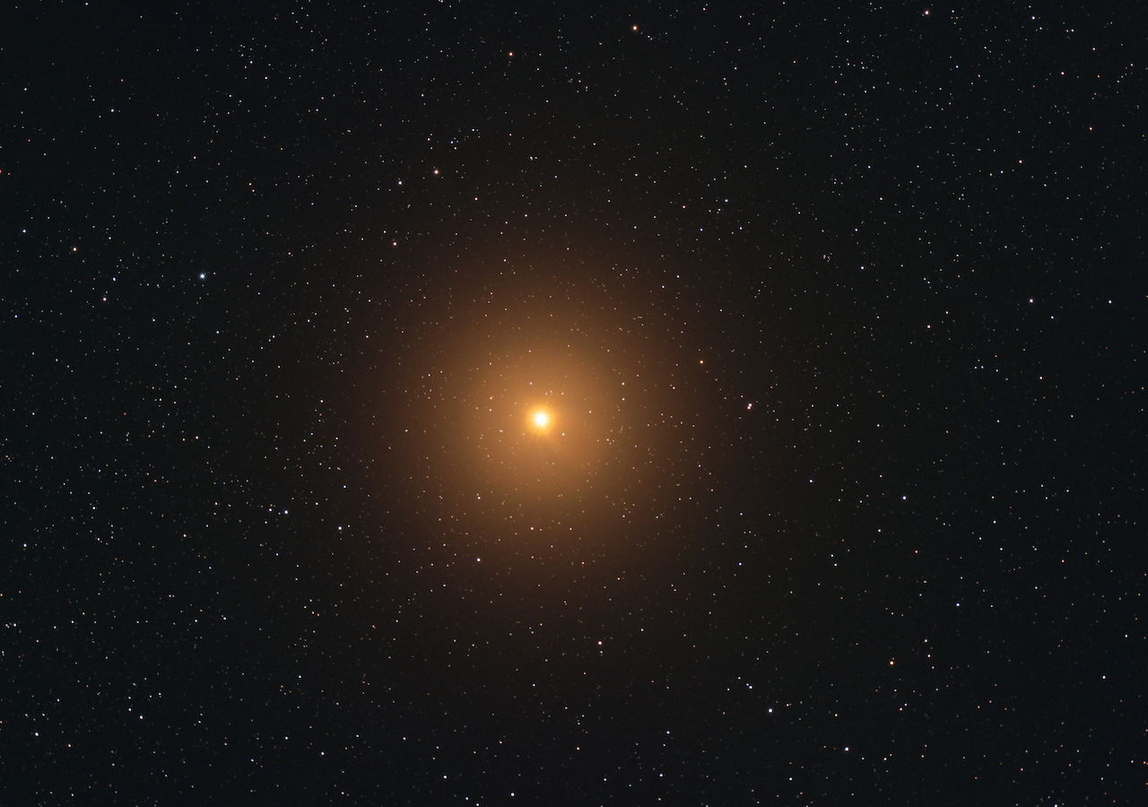 Nahaufnahme von Betelgeuse (Alpha Orionis), dem roten Riesenstern im Orion, umgeben von einem dichten Sternenfeld im tiefen Weltraum.