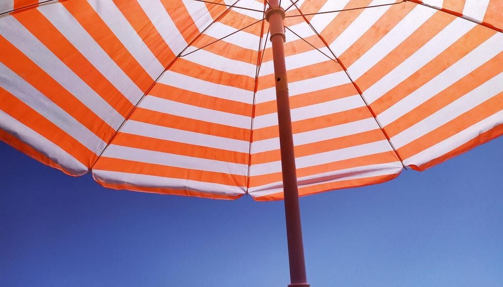 Le parasol à rayures de couleur vive nous plonge immédiatement dans la gaieté estivale. Le parasol à rayures de couleur vive nous plonge immédiatement dans la gaieté estivale.