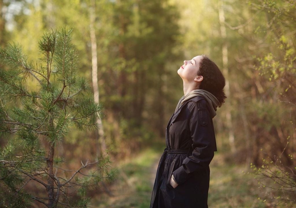 Rapariga numa floresta inspira ar puro Rapariga numa floresta inspira ar puro