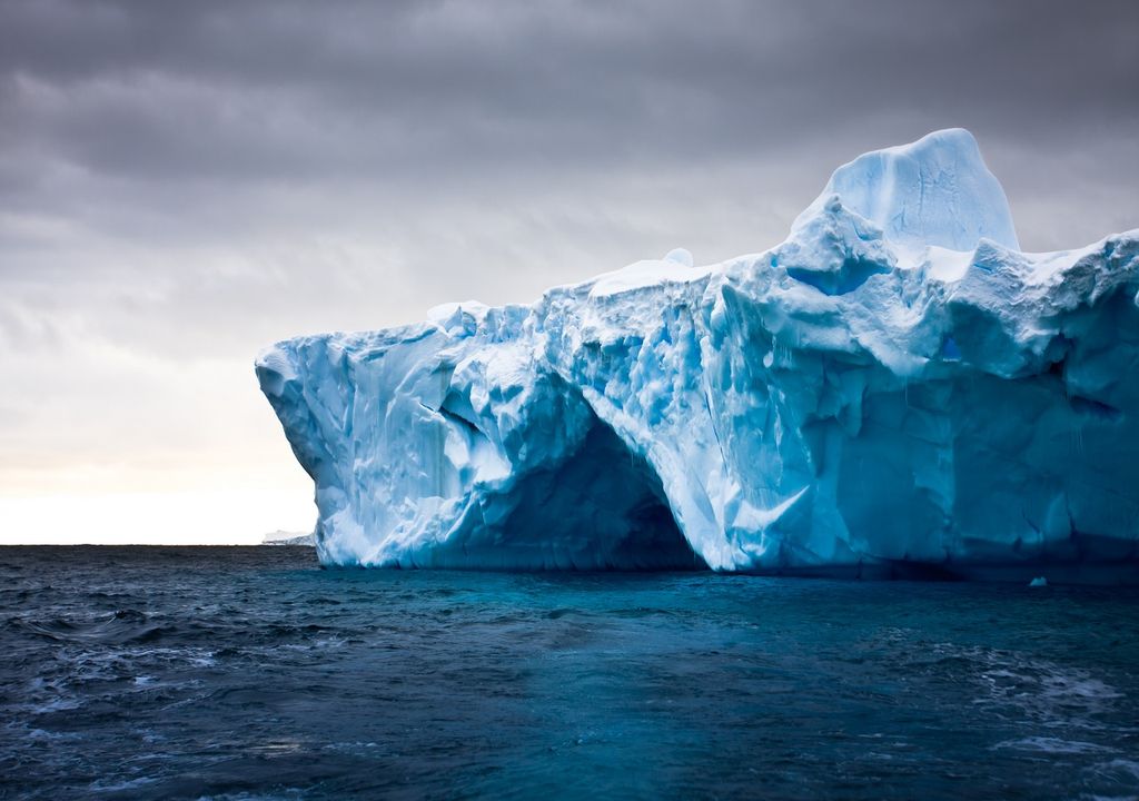Iceberg en el océano con cielo nublado y oscuro